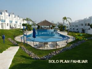 a swimming pool in a yard next to some buildings at Residencial Club Nautico Teques in Tequesquitengo