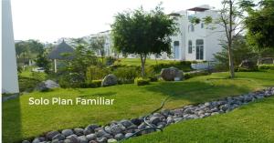 a garden in front of a white house at Residencial Club Nautico Teques in Tequesquitengo