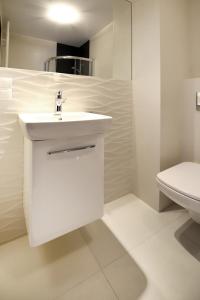 コシャリンにある100-SIO Apartamenty Budget Iの白いバスルーム(洗面台、トイレ付)