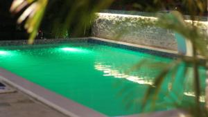 a swimming pool with green water in a house at Hotel Elegance NV in Paramaribo