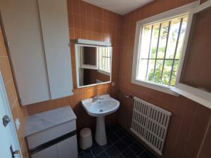ein kleines Badezimmer mit Waschbecken und Fenster in der Unterkunft ÀNCORA VELLA in Sant Antoni de Calonge + 32 Fotos