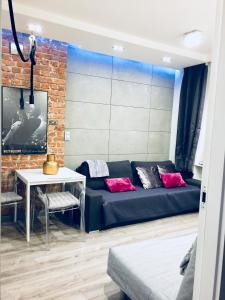 a living room with a blue couch and a brick wall at Old Town Apartment / Igielnicka in Gdańsk