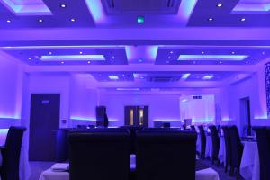une salle de conférence avec des chaises et des lumières violettes dans l'établissement The Charles Hotel, à Chatham