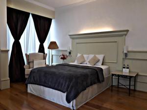 1 dormitorio con 1 cama grande y 1 silla en Casa Toscana Bed & Breakfast en San Miguel de Allende