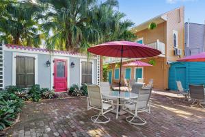 un patio con mesa, sillas y sombrilla en New Orleans Guest House en Nueva Orleans