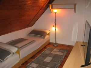 a bedroom with a bed and a floor lamp at Faragó Apartman in Nyíregyháza
