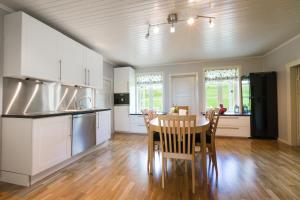 Rasmusgarden في ستراندا: مطبخ وغرفة طعام مع طاولة وكراسي