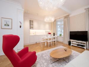 a living room with a red chair and a table at Harju Old Town Apartment in Tallinn