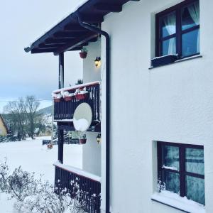 a house with a balcony in the snow at Chalet Ivana in Kupres