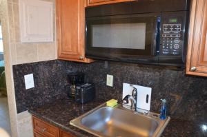 a kitchen counter with a sink and a microwave at La Terrace Oceanfront in Hollywood +45 photos