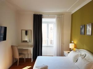 um quarto com uma cama, uma secretária e uma janela em More Cola di Rienzo B&B em Roma