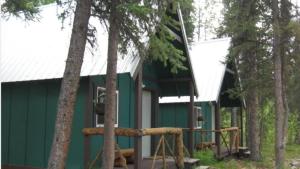ein grünes Gebäude mit Bäumen davor in der Unterkunft The Perch Resort in McKinley Park