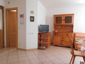 a living room with a tv and a wooden cabinet at Appartamento Zorzi in Ziano di Fiemme