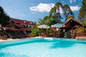 雷森迪德馬烏阿的住宿－韋達斯霍騰西亞酒店，一个带椅子和遮阳伞的大型游泳池