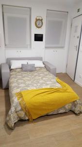 リスボンにあるStudio 63 Historic Centerのベッドルーム1室(黄色い毛布付きのベッド1台付)