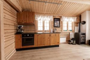 a kitchen with wooden cabinets and a stove in a room at Røde Kors in Brunstad