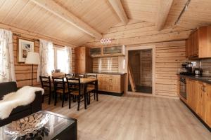 a kitchen and dining room in a log cabin at Røde Kors in Brunstad