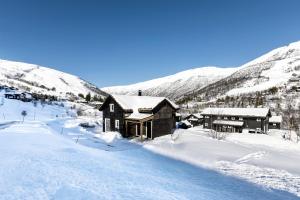 ストランダにあるSkarhaugvegen 2の山を背景にした雪の小屋