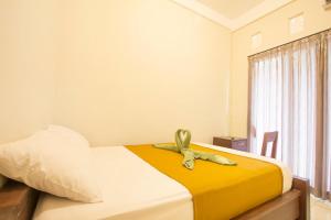 Postel nebo postele na pokoji v ubytování Putra Dadi Guest House