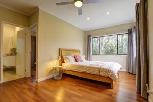 a bedroom with a bed and a large window at Cockatoo Hideaway- Cabin in Montville