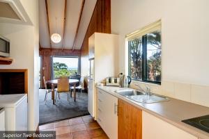 a kitchen with a sink and a refrigerator at Kaiteri Motels and Apartments in Kaiteriteri