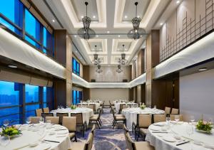a dining room with tables and chairs and windows at Modena by Fraser Changsha in Changsha