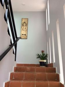 a stairway with a picture on the wall and a plant at Davyta House in Siem Reap