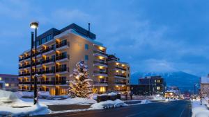 a building with a christmas tree in the snow at Chalet Ivy Hirafu in Niseko