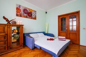 1 dormitorio con 1 cama y 1 sofá azul en VIP-Kvartira by na Kozlova, en Minsk