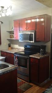 a kitchen with a stove and a microwave at Greer Point Trails End Cabins in Greer