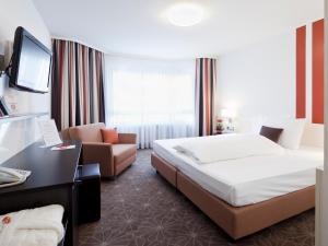 a hotel room with a bed and a couch at ZELLER's Quartier Hotel in Königsbrunn