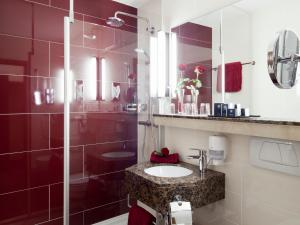 a bathroom with a sink and a glass shower at ZELLER's Quartier Hotel in Königsbrunn +52 photos