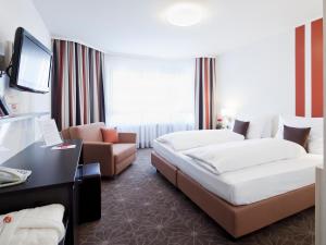 a hotel room with two beds and a couch at ZELLER's Quartier Hotel in Königsbrunn