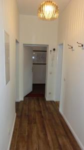 an empty room with a chandelier and a hallway at Apartment KiezFlair in Potsdam