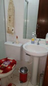 a bathroom with a sink and a toilet and a mirror at Apartamento no Guará por temporada in Brasilia