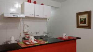 a kitchen with red and white appliances on a counter at Apartamento no Guará por temporada in Brasilia