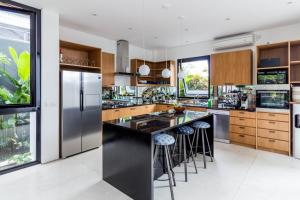 a kitchen with a large island with bar stools at Villa Pakuk in Canggu