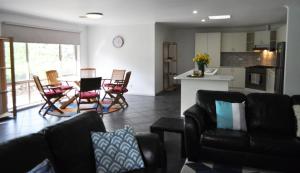 ein Wohnzimmer mit einem Tisch und Stühlen sowie eine Küche in der Unterkunft Island Breeze Motel in Currie