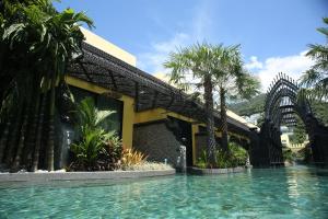 a resort with a swimming pool in front of a building at Sawasdee Village in Kata Beach