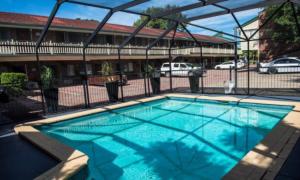 une grande piscine en face d'un bâtiment dans l'établissement Garden City Motor Inn, à Brisbane