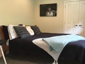 um quarto com uma cama e uma mulher numa fotografia em Lye Bow Lake House em Alexandra