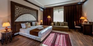 a bedroom with a large bed and a living room at Orient Star Hotel in Samarkand