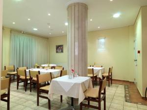 jadalnia ze stołami i krzesłami oraz kolumną w obiekcie Alex Hotel w mieście Tripolis