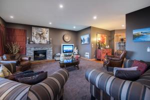 a living room with couches and a fireplace at The Flying Trout Boutique Lodge in Taupo