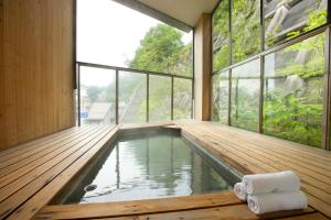 a swimming pool in a house with a large window at Kusatsu Hotel Bekkan Wata no Yu (Adult Only) in Kusatsu