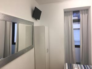 a bedroom with a mirror and a dresser and a tv at Albergue Santiago Apostol in Logroño +36 photos