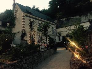 an old building with people sitting outside of it at Les Troglos de la Tufolière in Rochecorbon +34 photos