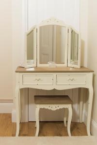 a white dressing table with a mirror on top at The Lodge at Heathfield in Ledbury