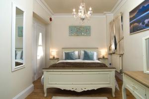 a bedroom with a large bed with a chandelier at The Lodge at Heathfield in Ledbury