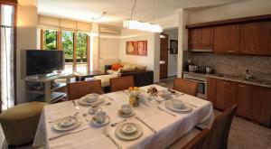 cocina y sala de estar con mesa y mantel blanco en Manolioudis Villas, en Balíon
